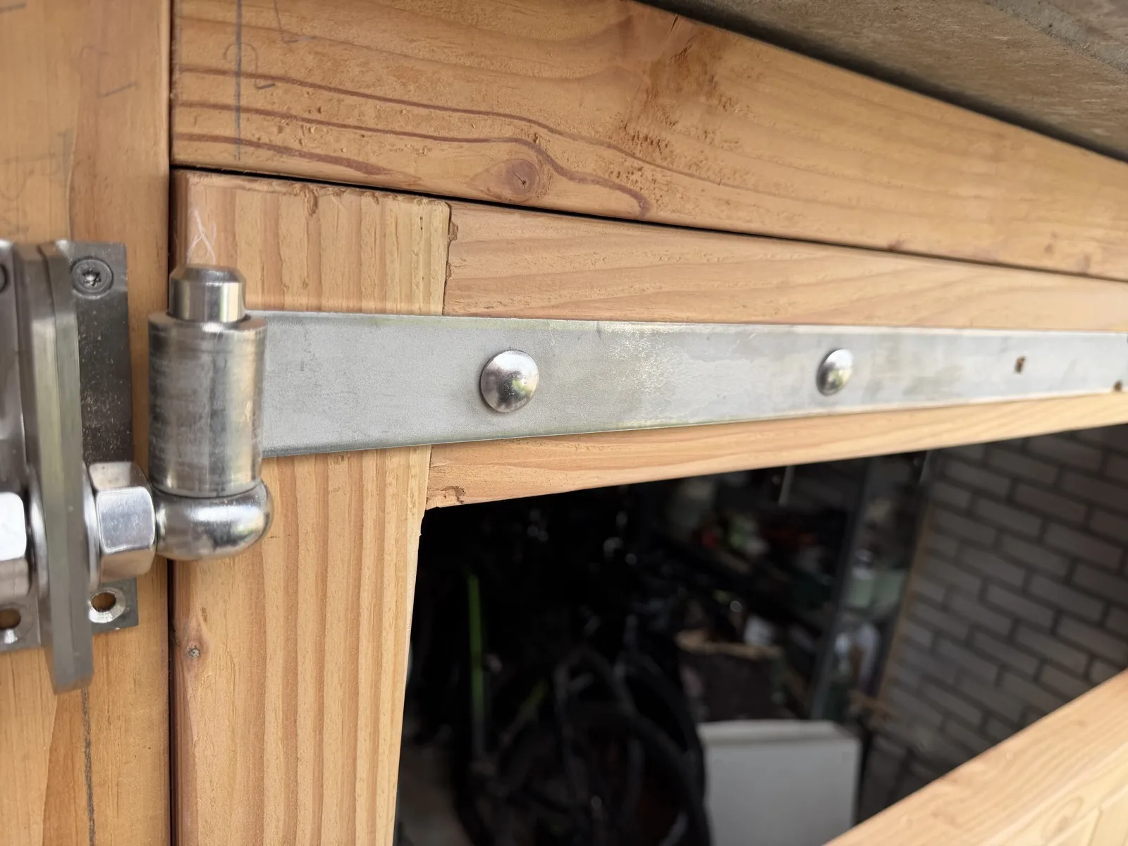 Verzonken scharnierbeslag op de rand van de houten garagedeur