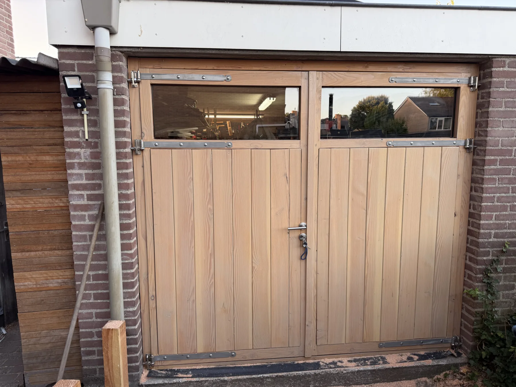 De afgebouwde garagedeuren met geplaatst glas in het avondlicht